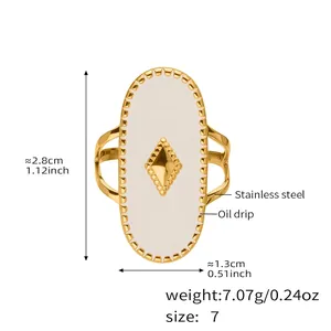 Vue détaillée d'une bague ovale en acier inoxydable doré avec émail blanc et diamant