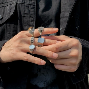 Close-up of vintage silver stackable rings featuring geometric textures on denim background
