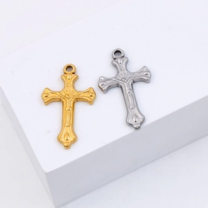 Detail of gold and silver stainless steel crucifix pendants on white display