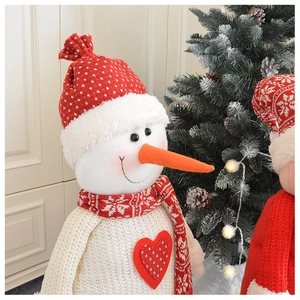 Dettaglio di un pupazzo di neve in maglia bianca con cuore rosso e cappello di Natale