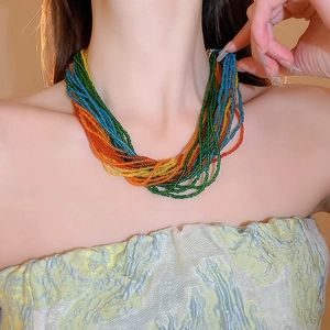 Dettaglio macro della collana bohémien a più strati di perline colorate su modella