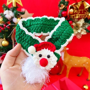 Detail of hand-knitted pet Christmas scarf with cute 3D Santa Claus ornament for small dogs