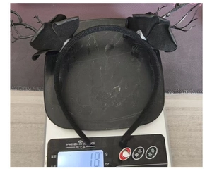 Detailed view of lightweight 18g Gothic black rose headband on a digital scale
