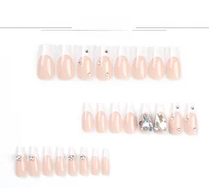 Detailed view of French press-on nails with pink base, white tips, and sparkling rhinestones
