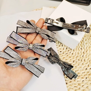 Detail of five handmade bow hair clips with crystal rhinestones and metal spring clips
