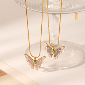 Close-up of golden snake chains with colorful enamel butterfly pendants on a clear stand