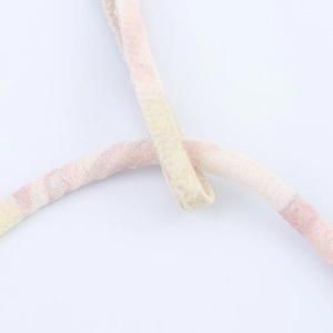 Dettaglio macro del cordoncino in tessuto a fiori rosa e gialli con trama a trama fitta