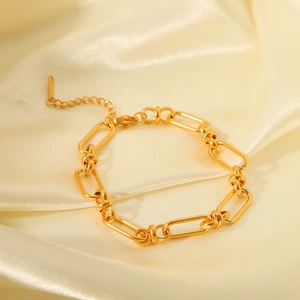 Polished 18K gold-plated stainless steel thick chain link bracelet on beige silk fabric