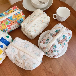 Detailed macro view of soft quilted cotton makeup bags with cute bear and floral prints