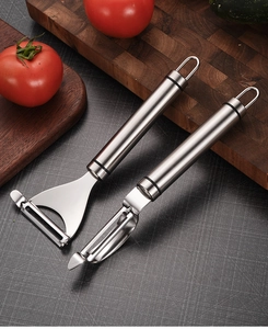Close-up of stainless steel Y-shaped and straight vegetable peelers on a dark background
