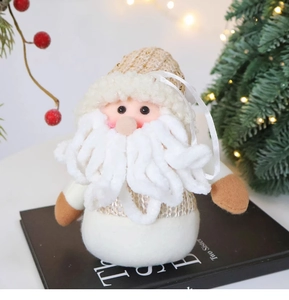 Close-up of handmade plush Santa ornament on a book with festive holiday background