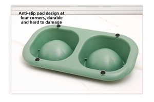 Detail view of the green pet bowl base featuring four anti-slip pads for stability