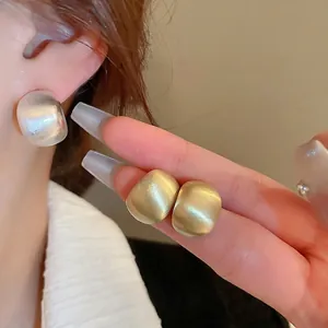 Brushed metallic C-shaped stud earrings in silver and gold finishes for a chic look