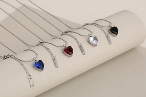 Detailed close-up of heart-shaped crystal pendants on stainless steel snake chains
