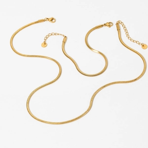 Set of two gold snake bone chain necklaces in minimalist stainless steel on white background