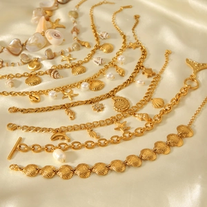 Detailed view of gold shell and starfish charms on stainless steel beach jewelry