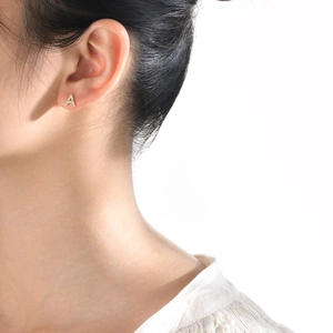 Minimalist gold letter A stud earring with cubic zirconia pavé on female model