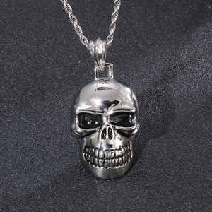 Detail of silver skull pendant with vintage patterns on a twisted rope chain