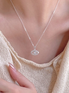 Close-up of sterling silver evil eye necklace with sparkling cubic zirconia on model