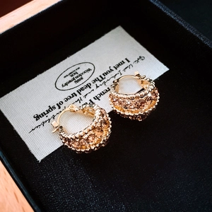 Close-up of gold hoop earrings with champagne crystals in a black jewelry gift box