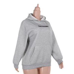 Detail of grey hooded sweatshirt with large front pocket and white background studio shot