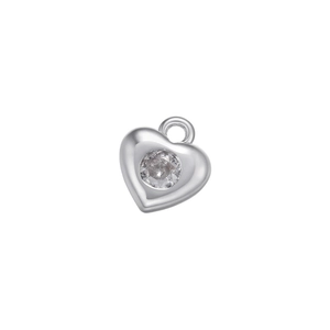 Macro detail of a silver heart pendant with a sparkling micro-set round zircon stone