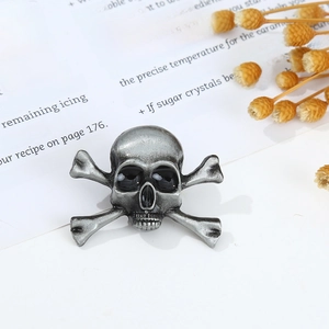 Macro shot of retro silver skull and crossbones brooch pin on a vintage book page