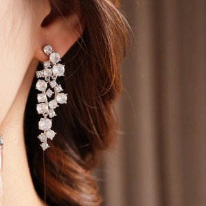 Close-up of elegant irregular zircon tassel earrings on a model with sparkling silver finish