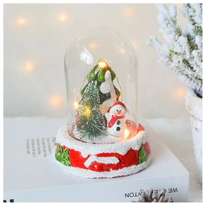 Detail of Christmas glass dome with snowman, LED lights, and festive holiday decor