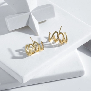 Detail showing gold-plated multi-row claw earrings with micro-inlaid clear zircons