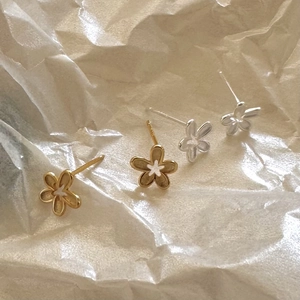 Minimalist 925 sterling silver daisy stud earrings in gold and silver finish on textured paper