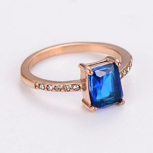 Macro shot of rectangular blue zircon ring in rose gold finish with side diamond accents