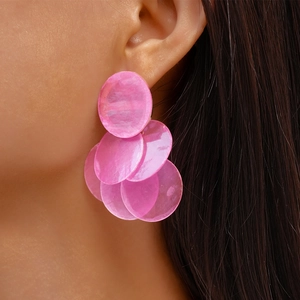 Close-up of pink layered round drop earrings with shell texture on female model