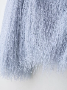 Detailed macro shot of light blue fringe fabric texture on a stylish fashion jacket