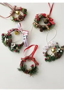 Detailed view of mini Christmas wreaths with pine cones berries and metal bells