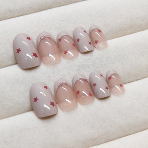 French bow press-on nails with red star patterns and nude grey glossy finish