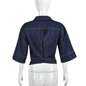 Detail of dark blue denim crop top featuring a criss-cross lace-up back and split hem