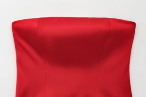 Détail du bustier en satin rouge montrant la texture luxueuse de la soie et sa finition