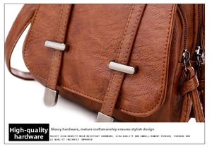 Close-up of brown litchi grain leather texture and silver matte metal buckle on bag