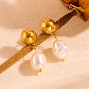 Close-up of 18k gold plated stud earrings featuring irregular white pearl tassels