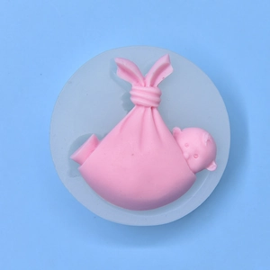 Sleeping baby shaped silicone mold for fondant and soap making on a blue background