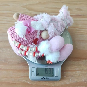 Detailed top view of a pink Valentine plush gnome being weighed on a digital scale