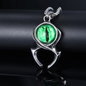 Vue macro détaillée d'un pendentif punk en acier avec griffe et oeil de démon vert