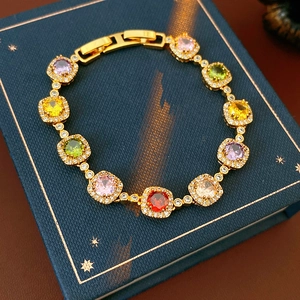 Detailed shot of vintage gold bracelet with multi-colored square zircon stones on jewelry box