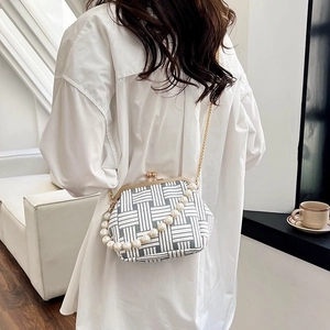 Elegant pearl handle shell bag with black and white geometric pattern on white shirt