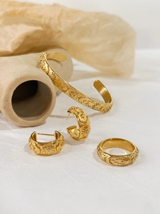 Detailed view of gold jewelry set with vintage sun and moon relief patterns and zircons
