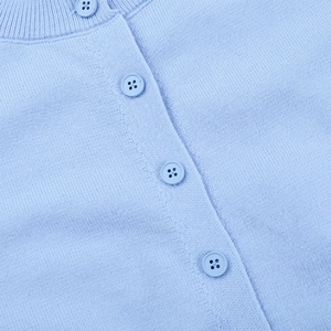 Gros plan détaillé d'un cardigan en maille bleu clair avec boutons à quatre trous