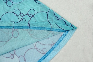 Detailed close-up of blue mesh fabric with artistic cartoon print and fine stitching