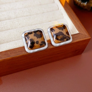 Vue macro de boucles d'oreilles carrées à motif léopard avec monture en métal argenté