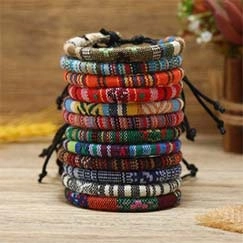 Macro shot of colorful braided anime themed bracelets on a rustic wooden texture